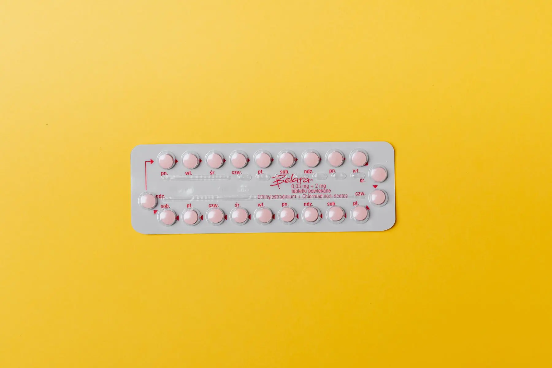 Blisterpackung mit rosa Tabletten auf gelbem Grund